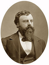 A bearded man wearing a suit and a bow tie