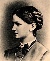 Side view of a young woman with dark hair braided up on her head