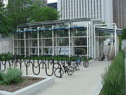Rows of outdoor bike racks in a plaza in front of a building