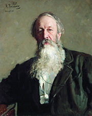 A man with grey hair and a long grey beard, wearing a dark jacket.