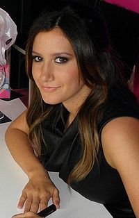 Head and shoulders of Tisdale in her twenties. Her dark brown, straight hair is parted in her left, and falls over her right ear.