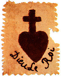 A black cross supported by a heart