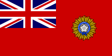 A British blue Ensign (a blue flag with the Union Jack placed at the top left corner) charged with the Star of India (five pointed star inside a circular band tied at the bottom)