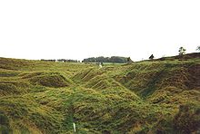 Uneven gullies in a grassy field