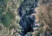 Jagged dark blue area of the gorge running form the bottom left to top right, surrounded by brown and green higher areas of land