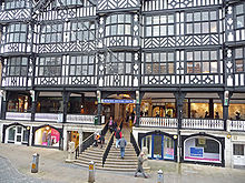 There are shops on the street level with wide steps leading to the first floor where there on more shops on the Rows.  Above this are 2+ storeys in black-and-white architecture.