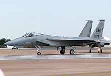 Gray jet aircraft taxiing left before take off, carrying no weapons under wings.