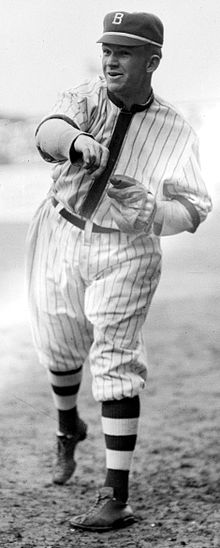 A man wearing a pinstriped baseball jersey and a cap with the letter "B" written on it having just thrown a baseball.