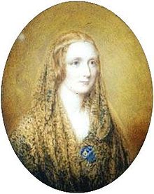 Oval portrait of a woman wearing a shawl and a thin circlet around her head. It is painted on a flax coloured background.