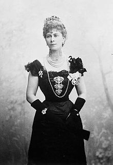 Thin lady wearing a formal dress, a rope of pearls and a tiara