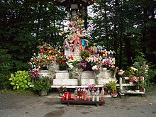 A statue, covered with flowers.
