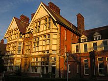Two 3-story gabled towers of Thanet College, in late sun.