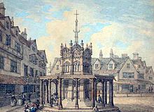 Squat octagonal structure, surrounded by tall thin buildings. A tall narrow structure, also octagonal, rises from it, topped by a cross.