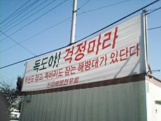 A banner in South Korea reads: "Dokdo! Don't worry, the ghost and jjokbari-catching Marines are here."[1]