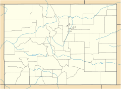 A map of Colorado in light yellow showing county boundaries and major rivers. There is a red dot in the center of Pitkin County, in the west central region of the state.
