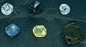 Six non-faceted diamond crystals of 2–3 mm size; the diamond colors are yellow, green-yellow, green-blue, light-blue, light-blue and dark blue