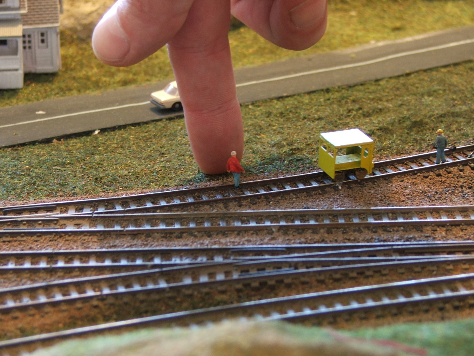 Photo of section of N scale layout with track and a human hand shown 