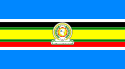 Nine horizontal strips colored in the following order (top to bottom): Blue, white, black, green, yellow, green, red, white, then blue. The logo of the EAC is placed in the center.