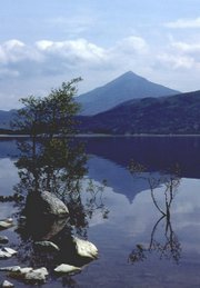 A symmetrical mountain is reflected in the waters of a lake.