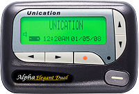 A gray boxlike object with rounded corners and buttons with arrowheads, circles and a dash. Text in the lower left hand corner reads "Alpha Elegant Dual". In the center is a luminous green liquid crystal display with "Unication" in large letters on top, a speaker and battery icon at the lower left and "12:20AM 01/05/08" in smaller text across the bottom