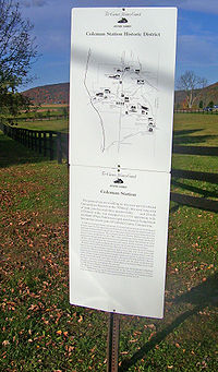 A white rectangular sign with a map and explanatory text on it headed by "Coleman Station Historic District