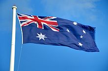 A large Australian flag flying against the blue sky.