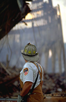 A New York firefighter working at the site of the World Trade Center, with wreckage visible in the background