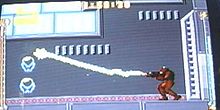 A video game screenshot of a person in a powered exoskeleton firing a beam.