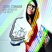 A portrait like a TV Show is Bommerang in a rainbow-like colour of a woman seductively posing with her jacket on her head. The Woman stands hand right and the black stands hand up on the rainbow colour. To the woman's left in black stands 'JODIE CONNOR NOW OR NEVER Feat. WILEY'.