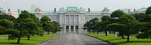 A large palace built of white stone in neo-baroque style. The facade is adorned with columns.
