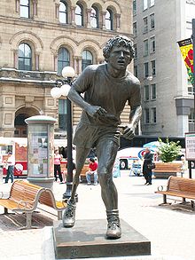 Statue of a runner with an artificial leg partially hunched forward.