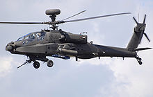 helicopter in flight rocket pods a machine gun and two blue missiles can be sen