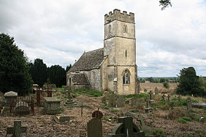 A stone church seen from the northwest.  The tower is battlemented, and the relatively small plain body of the church extends beyond it