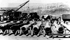 Long, tube-like casings. In the background are several ovoid casings and a tow truck.