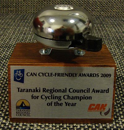 2009 award trophy: a wooden block bearing a plaque, and a bicycle bell mounted on top of the block