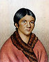 "A bust color portrait of a young Aboriginal women, in a red traditional shall with her dark hair tied back "